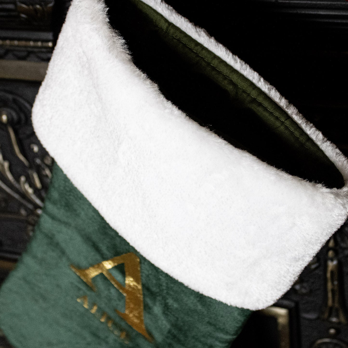 Green stocking with white cuff and gold letter 'A' on a dark background