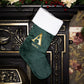 Green Christmas stocking with gold letter 'A' and name 'Alice' on a decorative fireplace.